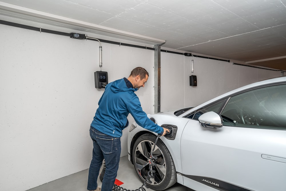 A homeowner plugging an EV into a garage wall charger