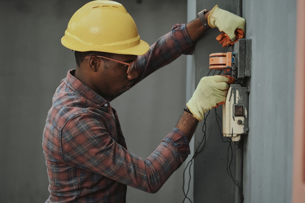 An electrician working inside an older home’s wiring